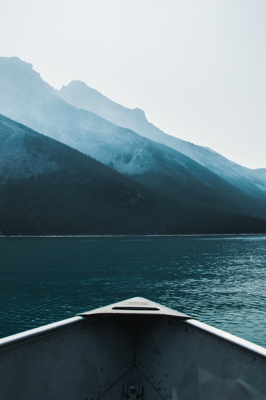 boat tip floating on rippling lake in mountainous terrain