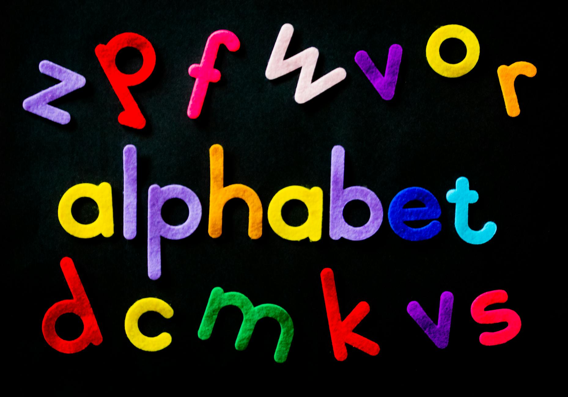 assorted color alphabet on black background