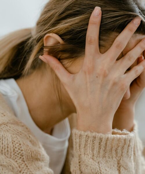 woman covering her face with her hands